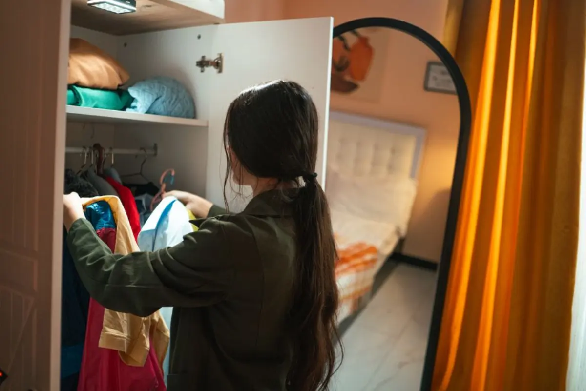 Geste de rangement dans une maison vécue